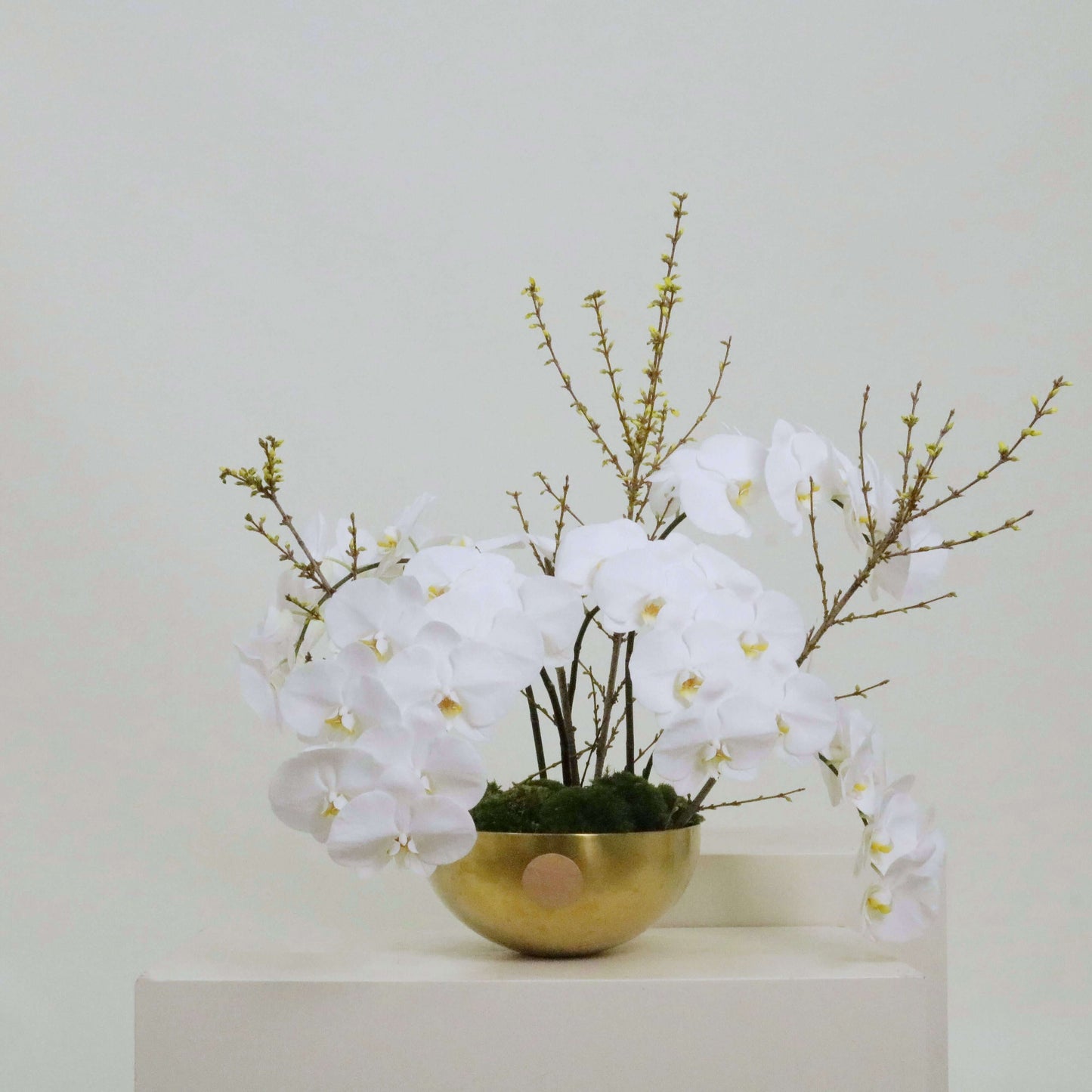 Heart Of Gold II arrangement featuring white orchids and forsythia, celebrating mothers with a gold heart design.