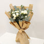 Hand-wrapped designer floral bouquets featuring white spray roses and eucalyptus in elegant wrapping.