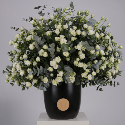 premium arrangement of white spray roses and eucalyptus in a stylish black vase.