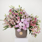 Luxury floral arrangement featuring pink lilies, peonies, and stocks in an elegant vase.