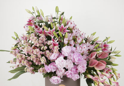 Luxury floral arrangement featuring lush pink lilies, peonies, and stocks in an elegant display.