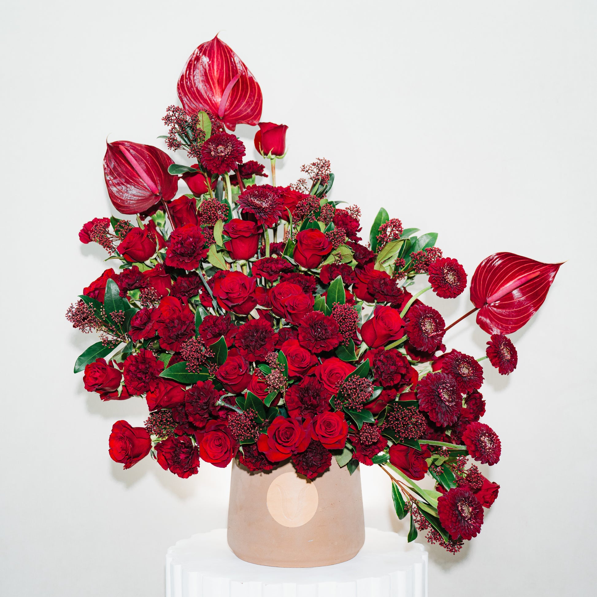 Bouquet of red flowers with a neutral vase on a white background