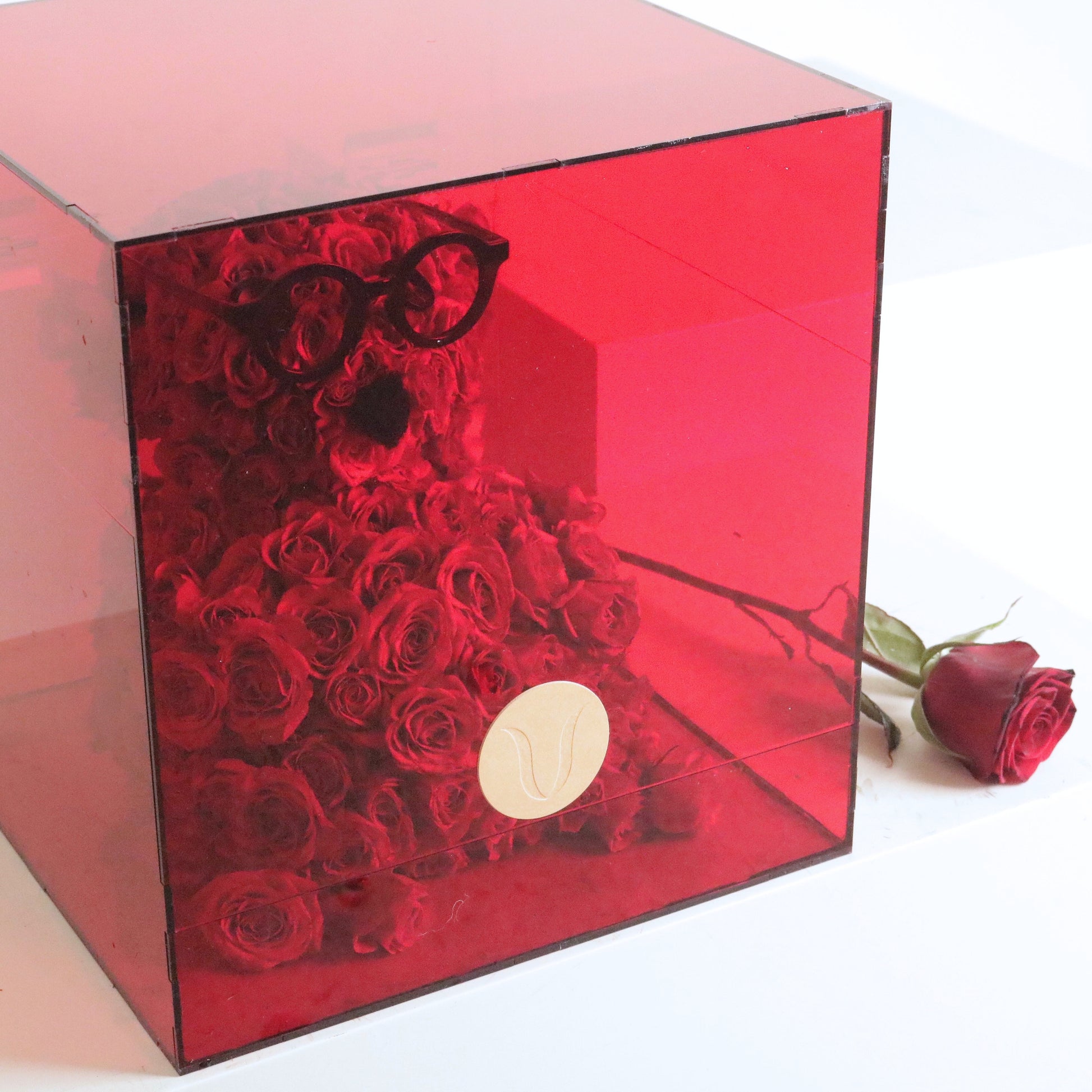 Hugs In A Box with over 90 rose stems, encased in a transparent red box, featuring a fresh design lasting up to 5 days.