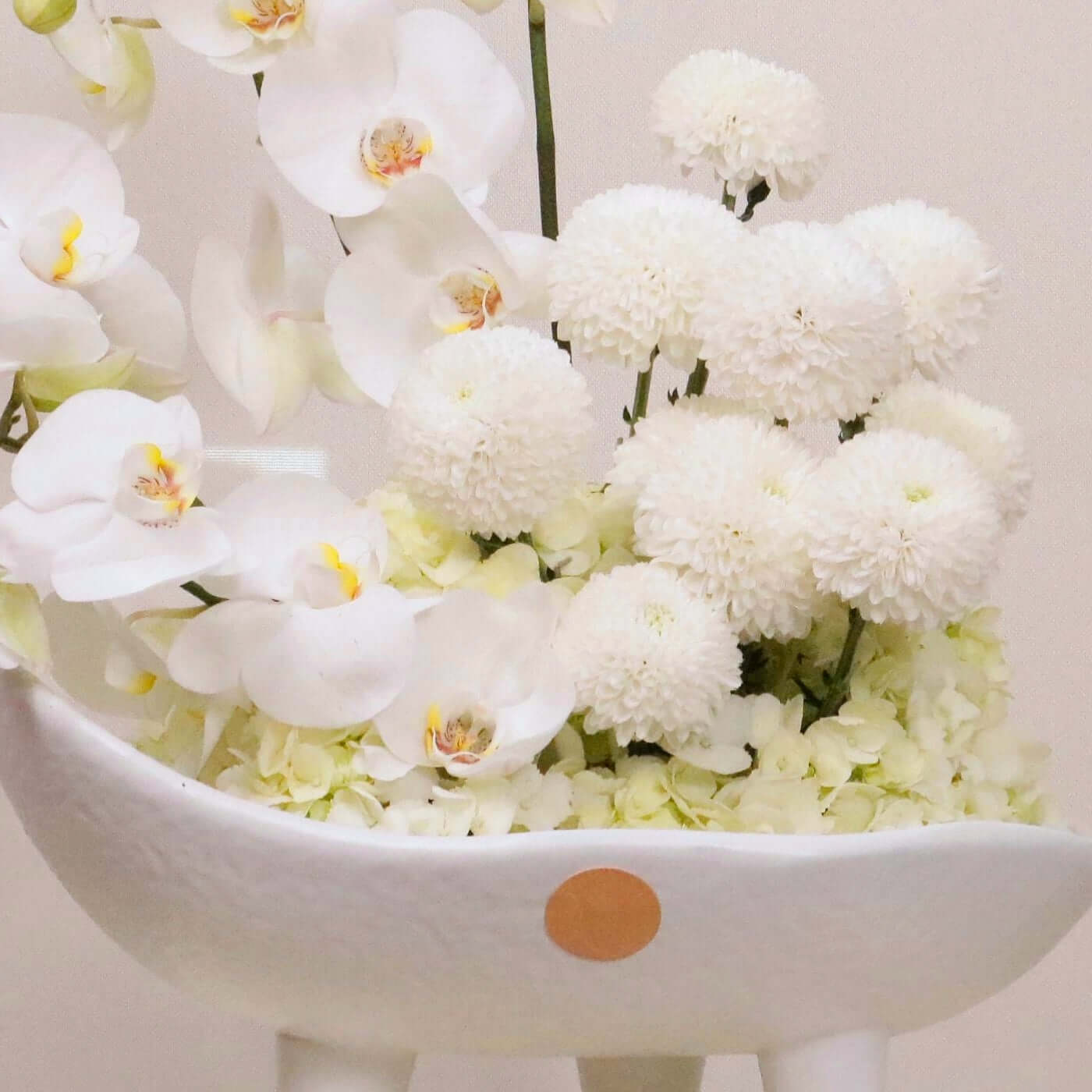 Luxurious floral arrangement 'Sonus Albus' featuring white Phalaenopsis orchids, hydrangeas, and ping-pong blooms in a stylish vase.