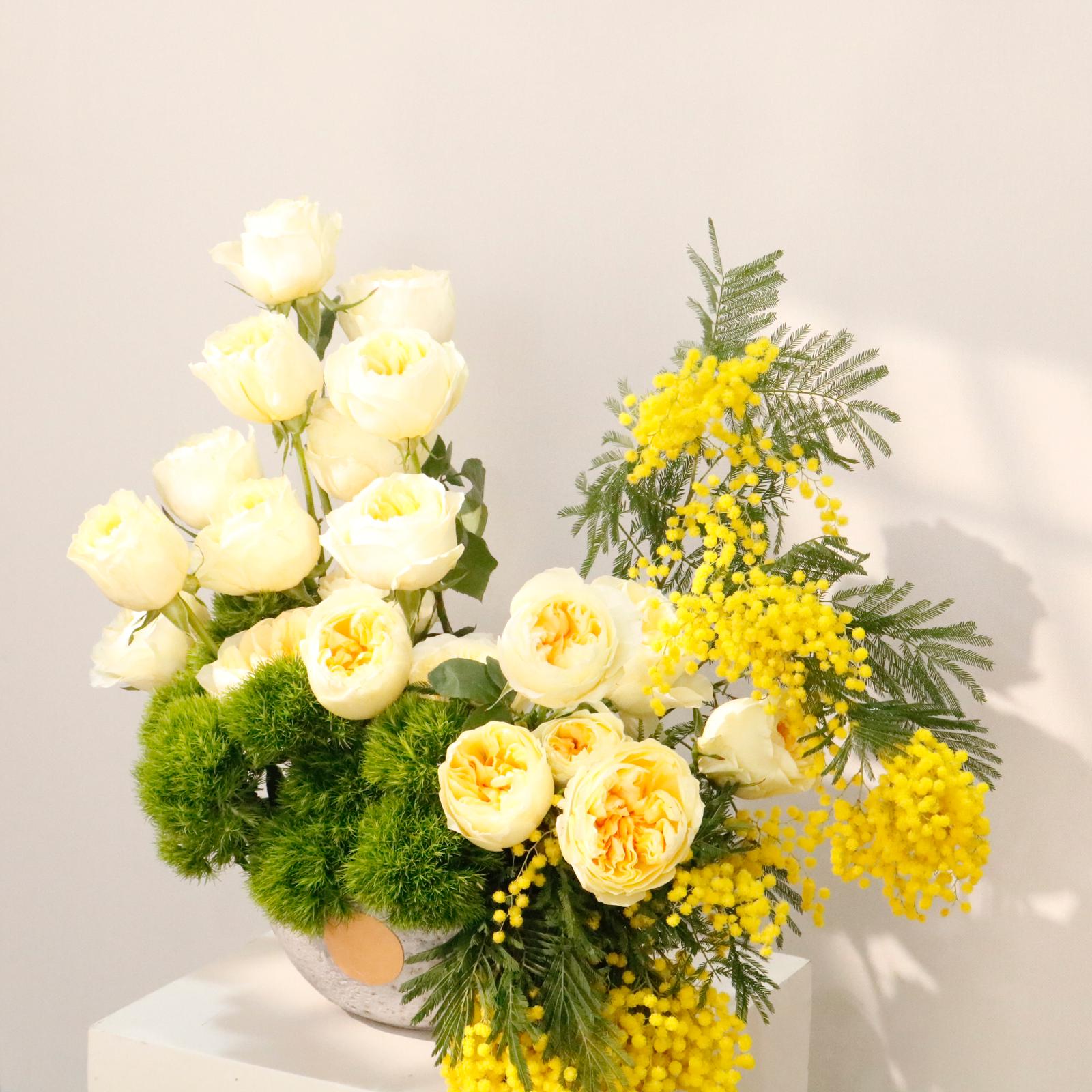 Perfect luxury gift idea. Shop Vitali Concept. Stunning stone vase arrangement with yellow mimosa, peonies, and premium roses.