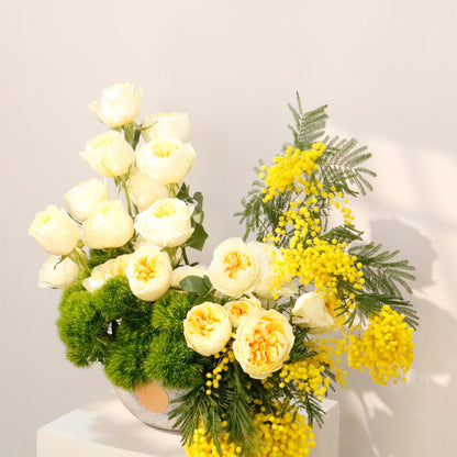 Perfect luxury gift idea. Shop Vitali Concept. Stunning stone vase arrangement with yellow mimosa, peonies, and premium roses.