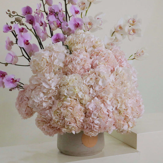 Pink hydrangeas and orchids in a lush floral arrangement inspired by Caruso Song, perfect for elegant and romantic occasions.