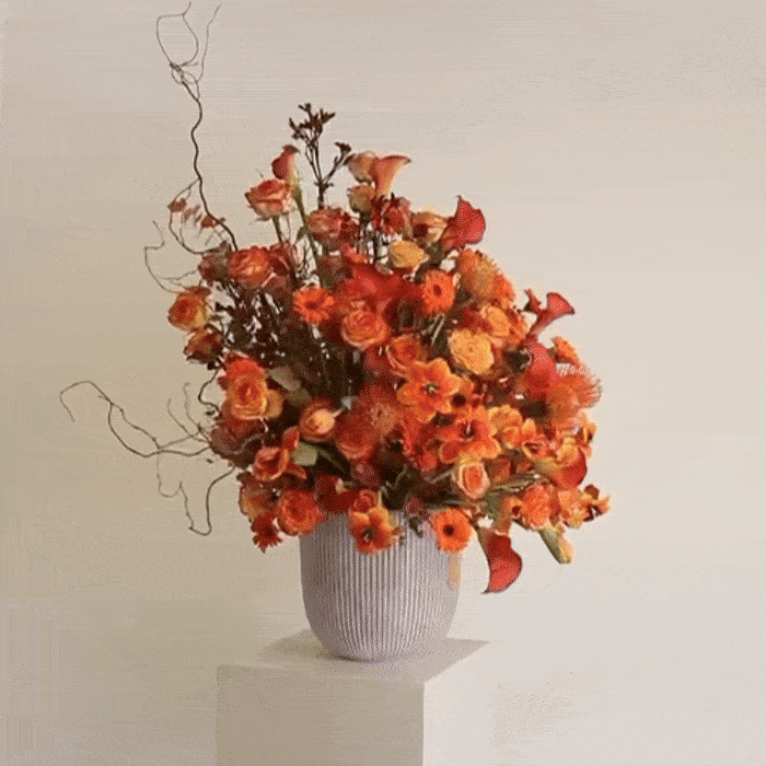 Sunset Symphony floral arrangement with orange calla lilies and rosa corolla branches inspired by Kuwaiti sunset elegance.