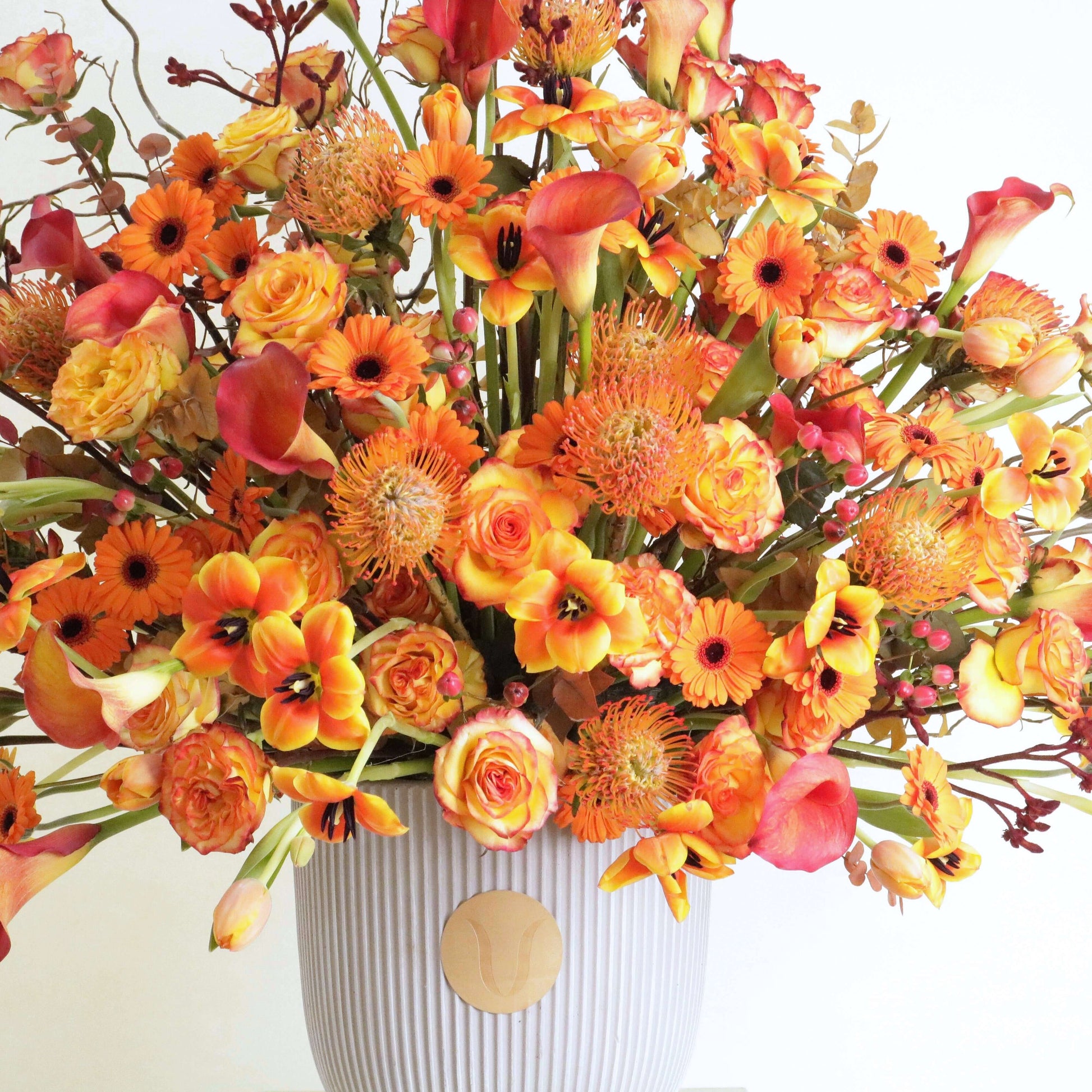 Sunset Symphony floral arrangement with orange calla lilies and rosa corolla branches inspired by a Kuwaiti sunset
