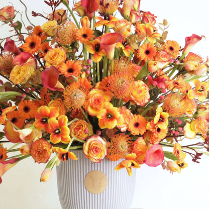 Sunset Symphony floral arrangement with orange calla lilies and rosa corolla branches inspired by a Kuwaiti sunset